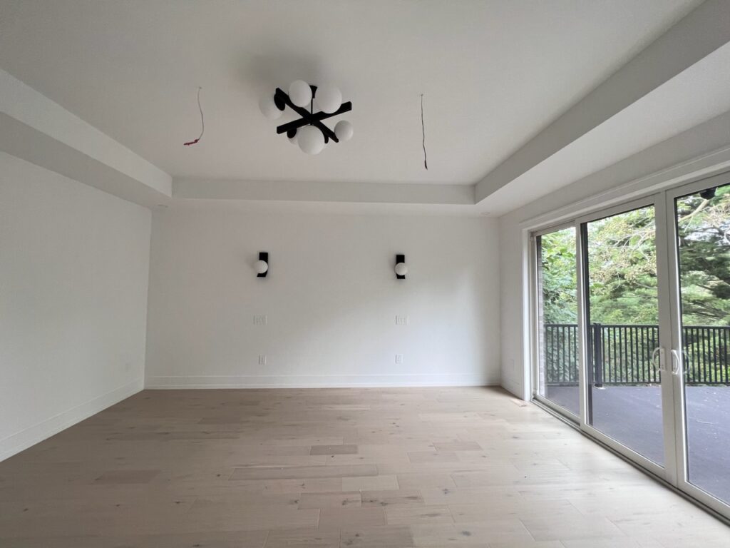 Spacious bedroom with a balcony painted white.
